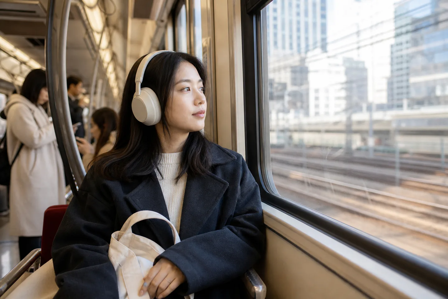 Commuter wearing over-ear headphones while riding a city train
