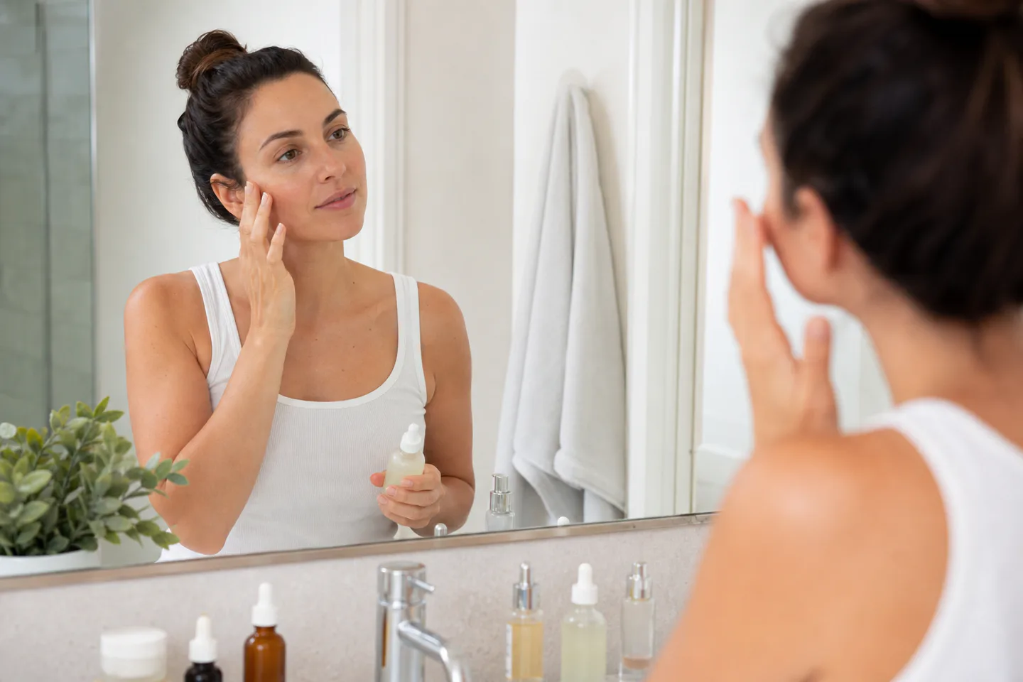 Woman applying an unbranded facial serum during a natural morning routine